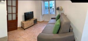 a living room with a couch and a flat screen tv at A Casa do Sastre1 in Ribadavia
