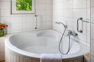 a white bath tub in a bathroom with a window at Ferienwohnung am Neumagen in Staufen im Breisgau +22 photos