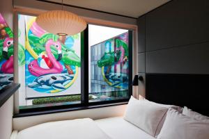 a bedroom with a bed and two windows with flamingos at citizenM Miami South Beach in Miami Beach