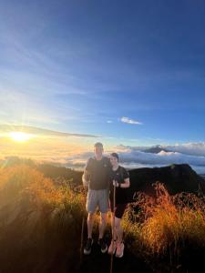 ein Mann und eine Frau stehen auf einem Berggipfel in der Unterkunft Mount Batur camping in Kubupenlokan