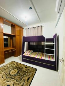 a bedroom with a purple bunk bed and a rug at Golf Avenue Homestay Kota Bharu in Pengkalan Cepa