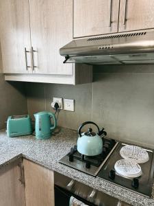 a teapot on a stove top in a kitchen at Nemesia Court in Durbanville +47 photos