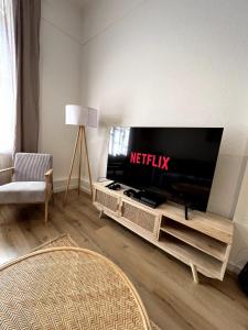 a living room with a flat screen tv on a entertainment center at Cozy City Oasis Central & Near Fairgrounds in Frankfurt/Main