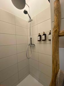 a shower with a shower head in a bathroom at Cozy City Oasis Central & Near Fairgrounds in Frankfurt/Main