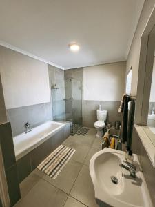 a bathroom with a tub and a sink and a toilet at Nemesia Court in Durbanville +59 photos