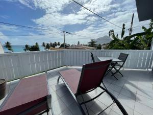 un patio con tavolo e sedie su un balcone di Martinique Studio Escale Diamant a Le Diamant