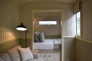 a small bedroom with a bed and a window at Ardmore Shepherd's Hut in Lochinver