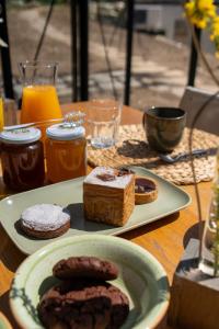 a table with a plate of cookies and a plate of bread at Vivi la Magia di Bisdalù - Dormi nella Stanza nel Bosco, Ammira le Stelle e Rilassati con l'Area Benessere e Colazione in Peveragno