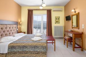 a hotel room with a bed and a desk and a window at Studios Rania - Rania Studios & Apartments in Lassi