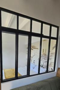 Cette chambre dispose d'une grande fenêtre avec des cadres noirs. dans l'établissement Frontignan petite maison coquette 30 m2 à 100 m de la plage, à Frontignan 3 autres photos