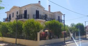 a white house with a fence in front of it at Ilida Kourouta Studios in Kourouta