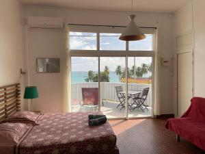 una camera da letto con un letto e vista sull'oceano di Martinique Studio Escale Diamant a Le Diamant
