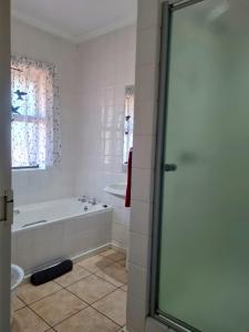 a white bathroom with a tub and a shower at Point Village Accommodation - Galathea 6 in Mossel Bay