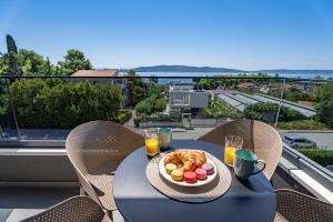 a table with a bowl of food and drinks on a balcony at Luxury apartments Olive in Kaštela