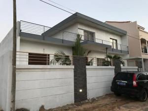 Keur Ndiaye LôCheerful flat with terrace in contemporary duplex with trees and garden的停在房子前面的汽车