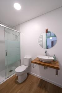 a bathroom with a toilet and a sink and a mirror at Casa Alba, desde 1926 in Alvados