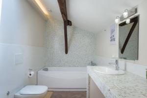 a bathroom with a tub and a toilet and a sink at Luxury Penthouse in the heart of Bologna in Bologna +38 photos
