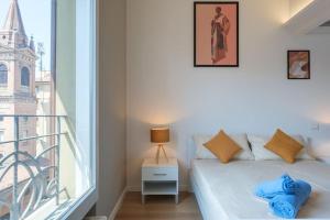 a room with a bed and a balcony with a window at Luxury Penthouse in the heart of Bologna in Bologna