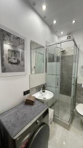 a bathroom with a glass shower and a sink at Mieszkanie in Bolesławiec