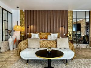 a living room with a couch and a table at Le Confidentiel Hôtel & SPA in Saint-Raphaël