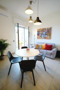 a living room with a table and chairs and a couch at Riflessi DaMare Room & Apartment in Salerno