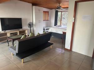 Una sala de estar con un sofá y un televisor. en Sea Vista - awesome sea views, en Durban