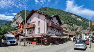 インターラーケンにあるホテル ロッスリの山のある通り沿いにある建物