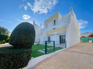 Una casa blanca con un gran arbusto delante de ella. en Galé Premium House - Pet Friendly, en Albufeira