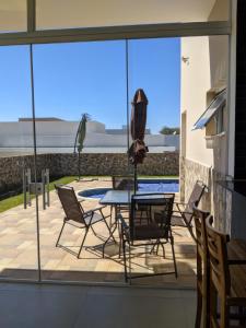 a patio with a table and chairs and a pool at Casa para Temporada No Ninho verde 1 in Quadra