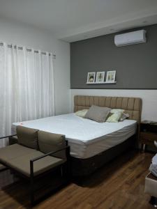 a bedroom with a bed and a chair at Casa para Temporada No Ninho verde 1 in Quadra +16 photos