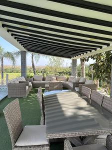a patio with a table and chairs under a roof at Super belle villa avec piscine in Fez