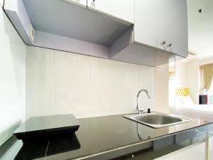 a kitchen with a sink and a counter top at Good Choice Studio Room at Gateway Pasteur Apartment By Travelio in Bandung