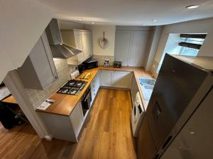 mit Blick auf eine Küche mit weißen Schränken in der Unterkunft Whitebrook Cottage in Mellor