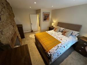 ein Schlafzimmer mit einem Bett und einer Steinwand in der Unterkunft Whitebrook Cottage in Mellor