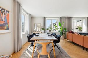 a living room with a wooden table and chairs at Luksus Aarhus C-lejlighed med Panorama Udsigt in Aarhus +18 photos