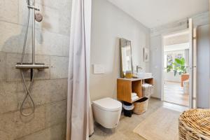 a bathroom with a toilet and a shower at Luksus Aarhus C-lejlighed med Panorama Udsigt in Aarhus