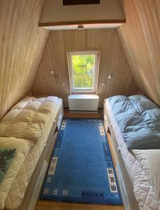 two beds in a small room with a window at Bootshaus am Inselseekanal in Güstrow