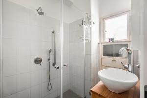 a white bathroom with a shower and a sink at Ben Yehuda Elegant City Retreat with Shelter by Sea N Rent in Tel Aviv +26 photos