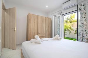 GázionにあるComfy Beachside Flatの白いベッドルーム(大型ベッド、タオル付)
