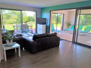 a living room with a couch and a table at Maison avec Piscine intérieure privée sans vis à vis chauffée toute l année in Quiévrecourt