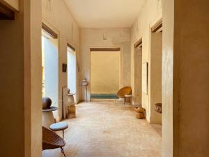 a hallway with chairs and a window in a building at Swahili Dreams Apartments in Lamu