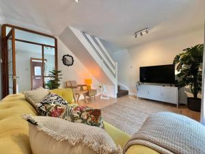 a living room with a yellow couch and a tv at Perfect Very Central and Peaceful Oxford Home with Free Parking & Private Garden - in Oxford