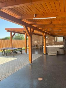a wooden pavilion with benches and tables on a patio at Ikervár-lak in Ikervár