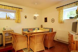 a dining room with a wooden table and wicker chairs at Haus Alfred, Aitern, Belchen, Schwarzwald in Aitern