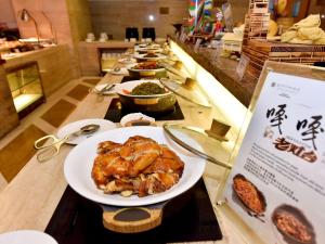 a buffet with a plate of food on a table at Pullman Zhangjiajie Hotel - Instagrammable in Zhangjiajie