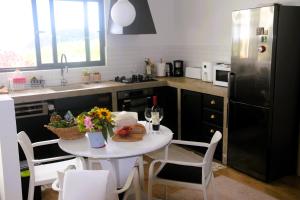 a kitchen with a table with flowers and a refrigerator at Apartamento tranquilo e acolhedor in Ponta Delgada