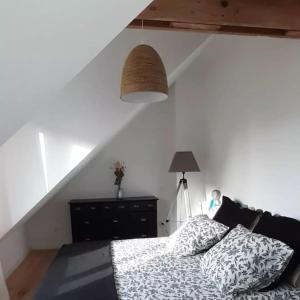 ポール・ルイにあるJolie maison de pêcheur en bord de merのベッドルーム1室(ベッド1台、ランプ、階段付)