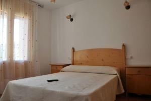 a bedroom with a bed with a wooden headboard and a window at Casa Serrano in Letur