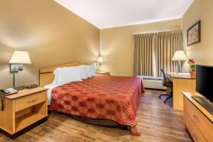 a hotel room with a bed and a flat screen tv at Econo Lodge Colorado Springs near Airport in Colorado Springs