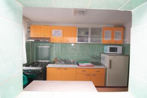 ストラジャにあるLa David Strajaのキッチン(オレンジ色のキャビネット、白い冷蔵庫付)